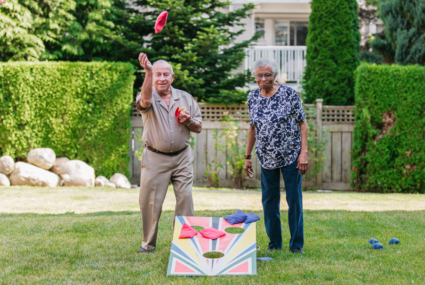 senior man and woman playing cornhole