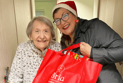 Senior receiving gifts from Bria Communities staff